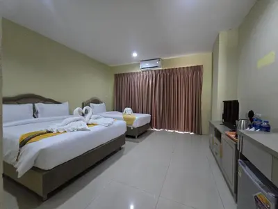 a hotel room with two beds and a television at Blue Sapphire Hotel in Patong Beach