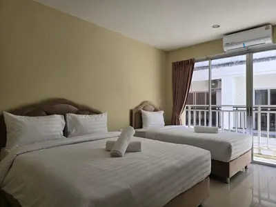 two beds in a hotel room with a balcony at Blue Sapphire Hotel in Patong Beach