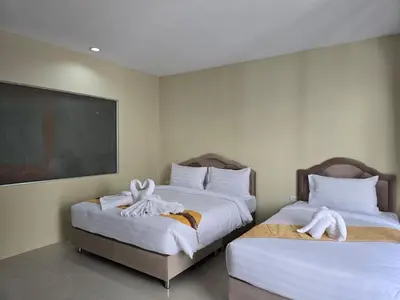two beds in a hotel room with towels on them at Blue Sapphire Hotel in Patong Beach
