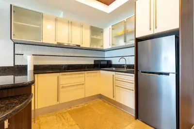 a kitchen with white cabinets and a stainless steel refrigerator at Sea view apartment at Bel Air Panwa in Ban Ao Makham