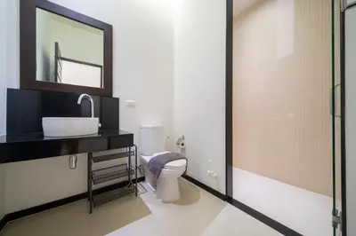 a bathroom with a toilet and a sink and a mirror at Tropical retreat-pool villa at Oxygen Bangtao in Ban Thalat Choeng Thale