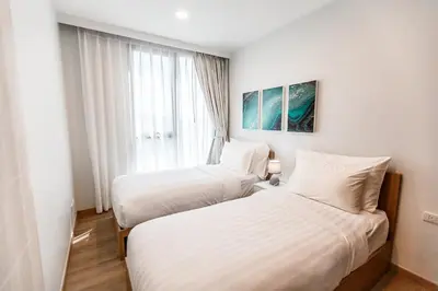 two beds in a hotel room with a window at Sky Park Golg View 2BR Bang Tao Laguna in Laguna Phuket
