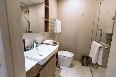 a bathroom with a sink and a toilet and a mirror at Sky Park Golg View 2BR Bang Tao Laguna in Laguna Phuket