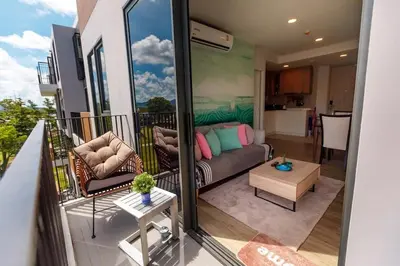 a living room with a couch on a balcony at Sky Park Golg View 2BR Bang Tao Laguna in Laguna Phuket