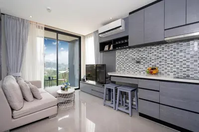 a living room with a couch and a kitchen at Modern Residence Tropics CTG-L709 with Medical and Wellness Center in Kamala Beach