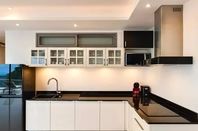 a kitchen with white cabinets and a sink at The Seaview Kata in Kata Beach