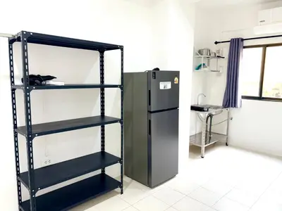 a black shelf next to a refrigerator in a room at Patong Canal Villa 103 in Patong Beach