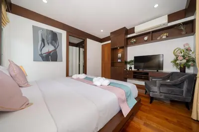 a bedroom with a large white bed and a flat screen tv at Villa with Huge Private Pool and Tropical Garden Just 10 Minutes Walk to Kamala Beach in Kamala Beach