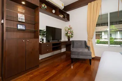 a bedroom with a desk with a television and a chair at Villa with Huge Private Pool and Tropical Garden Just 10 Minutes Walk to Kamala Beach in Kamala Beach