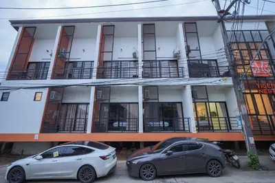 two cars parked in front of a building at Tiger Nest Stay in Ban Suan