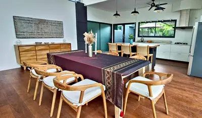 a kitchen and dining room with a table and chairs at Sarang Jati Mansion in Ban Saiyuan (1)