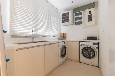 a kitchen with a sink and a washing machine at ANGSANA Coastal Bliss Penthouse 3bds Apartment with pool in Laguna Phuket