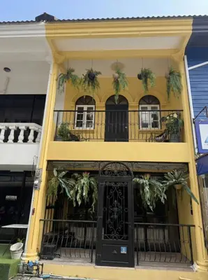 a yellow building with a black door and windows at New Five Star Home- Patong Beach in Patong Beach