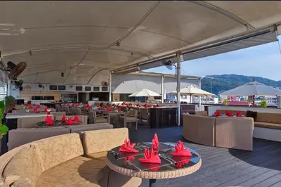 a restaurant with couches and tables with red flowers on them at Studio Bangla Suite 304 in Patong Beach