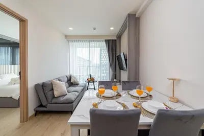a living room with a table and a couch at Ozone Modern in Laguna Phuket