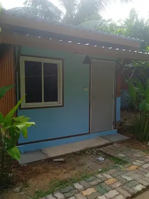 a small house with a blue wall and a window at Bang risskee home stay1 in Ko Yao Noi