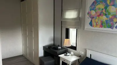 a room with a bed and a table with a lamp at Апартаменты Пхукет in Phuket Town
