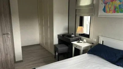 a bedroom with a bed and a desk with a lamp at Апартаменты Пхукет in Phuket Town