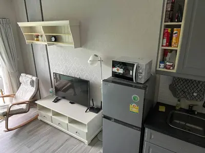 a small kitchen with a refrigerator and a table at Апартаменты Пхукет in Phuket Town