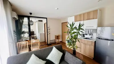 a living room with a couch and a kitchen at Title V - 1 br Bamboo Rawai Apartment in Karon Beach