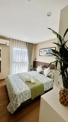 a bedroom with a bed and a potted plant at Title V - 1 br Bamboo Rawai Apartment in Karon Beach