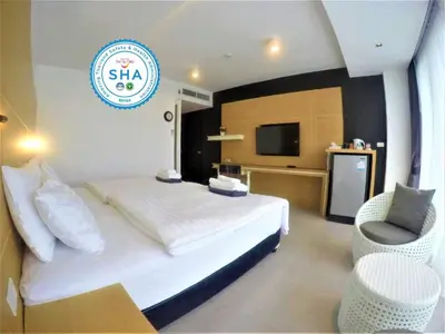 a hotel room with a bed and a television at Vivace Hotel in Kamala Beach
