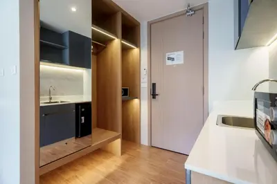 a small kitchen with a sink and a door at Beachfront 1524 Wyndham Gardens Condo Naithon in Phuket Town