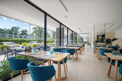 a restaurant with tables and chairs and windows at Beachfront 1524 Wyndham Gardens Condo Naithon in Phuket Town
