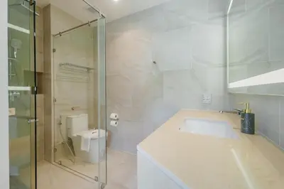 a bathroom with a sink and a glass shower at Wyndham Gardens 2413 Elegant Studio Forest View in Phuket Town