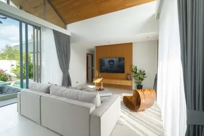 a living room with a white couch and a tv at Botanica Aroon Luxury Pool Villa 3 BR Lagoona Bangtao beach in Ban Pak Lak