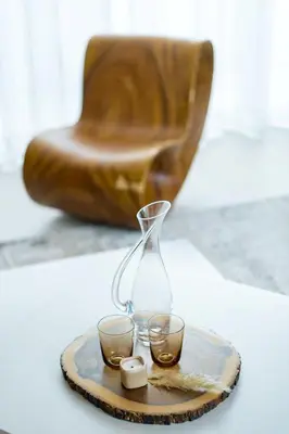 a glass vase and two candles on a tray with a chair at Botanica Aroon Luxury Pool Villa 3 BR Lagoona Bangtao beach in Ban Pak Lak