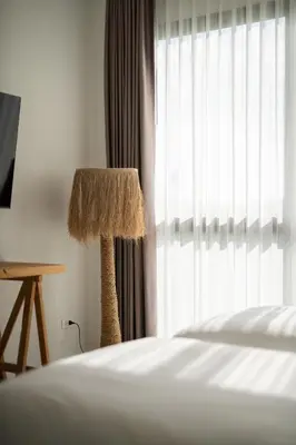 a bedroom with a bed and a lamp next to a window at Phang nga Villas Private Pool & Tropical Retreats