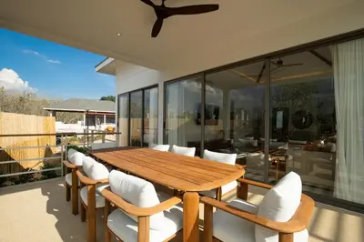 a wooden dining table and chairs on a patio at Phang nga Villas Private Pool & Tropical Retreats