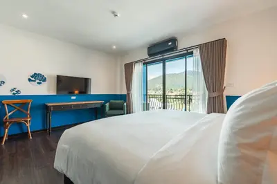 a bedroom with a bed and a desk and a window at Blu Monkey Boutique Naiharn Beach in Nai Harn Beach