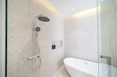 a bathroom with a shower and a bath tub at Modern and elegant 4-bedroom pool villa suitable for families - V10 in Ban Pak Lak