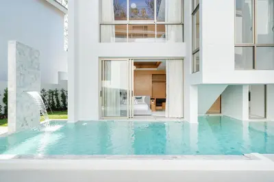 a house with a swimming pool in front of a building at Modern and elegant 4-bedroom pool villa suitable for families - V10 in Ban Pak Lak