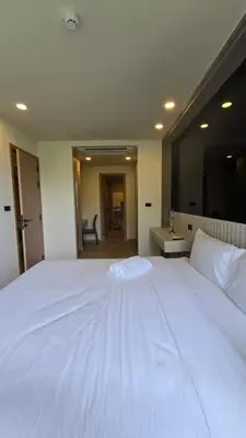 a large white bed in a room with a sink at The Ozon Condotel by SP in Laguna Phuket