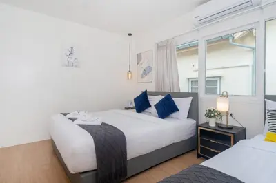 a bedroom with two beds and a window at Chill Beach Bangla comfy bed and pool 3 bedrooms 10pax in Patong Beach