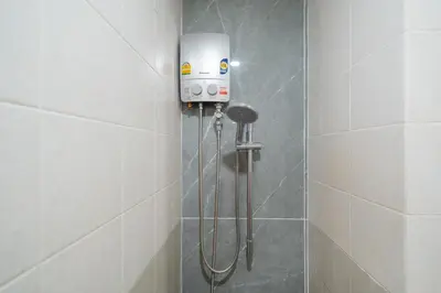 a shower with a shower head in a bathroom at Chill Beach Bangla comfy bed and pool 3 bedrooms 10pax in Patong Beach