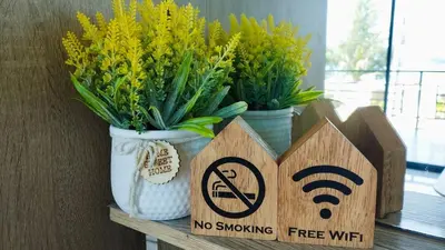 a no smoking sign on a table with flowers at Leamsai Whisper Home in Thalang