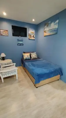 a blue bedroom with a bed and a tv at Leamsai Whisper Home in Thalang