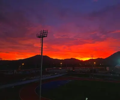 a sunset over a baseball field with a red sky at Work & Travel in Kathu