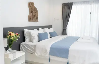 a bedroom with a bed with a statue of a monkey at Brickotel Naithon Beach in Nai Thon Beach