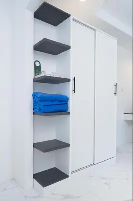 a closet with white walls and black shelves at Brickotel Naithon Beach in Nai Thon Beach