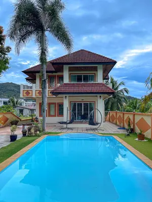 a villa with a swimming pool in front of a house at The Beige Pool Villa Bang Tao Phuket in Ban Thalat Choeng Thale