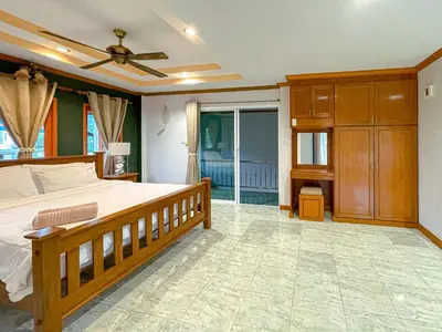 a bedroom with a wooden bed and a balcony at The Beige Pool Villa Bang Tao Phuket in Ban Thalat Choeng Thale