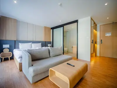 a living room with a couch and a bed at Wyndham Garden 1220 Modern Studio Next to Naithon in Phuket Town