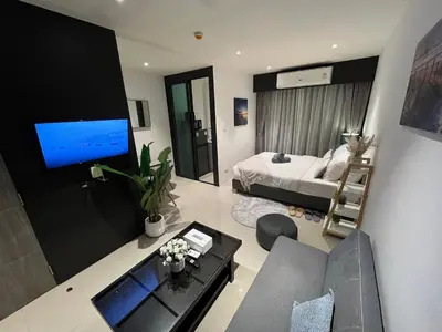 a living room with a couch and a bed and a television at Utopia Central in Ban Ket Ho