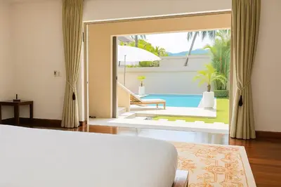 a bedroom with a door open to a pool at Luxury Pool Villa Bangtao Phuket close to beach in Bang Tao Beach