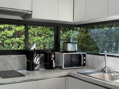 a kitchen counter with a microwave and a sink at Chalong Modern 2 bedroom pool villa in Ban Suan